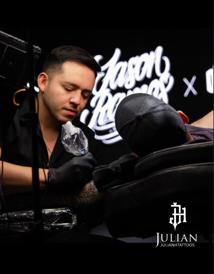 Julian tattooing at his station